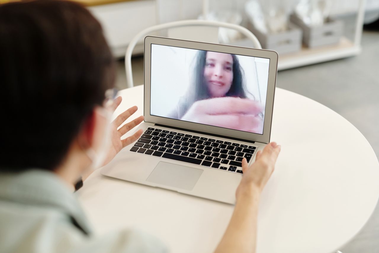 A person having a video call on a laptop, indoors, showcasing digital communication.